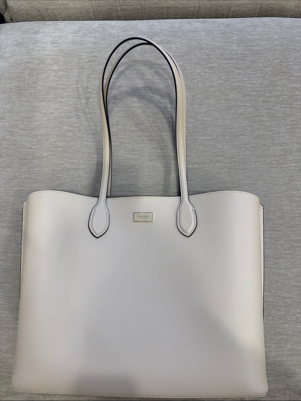 kate spade cream pebbled leather tote with black-edge straps